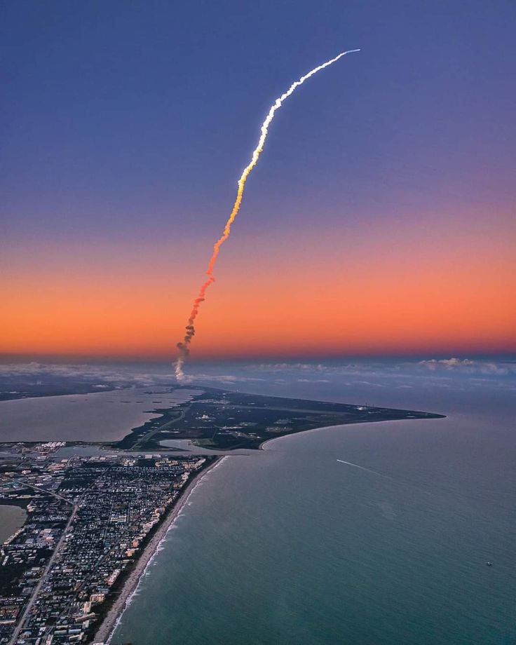 an airplane that is flying in the sky with a trail coming from it's tail