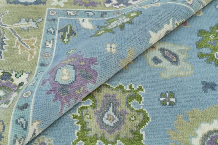 the fabric is blue and green with flowers on it, as well as an area rug