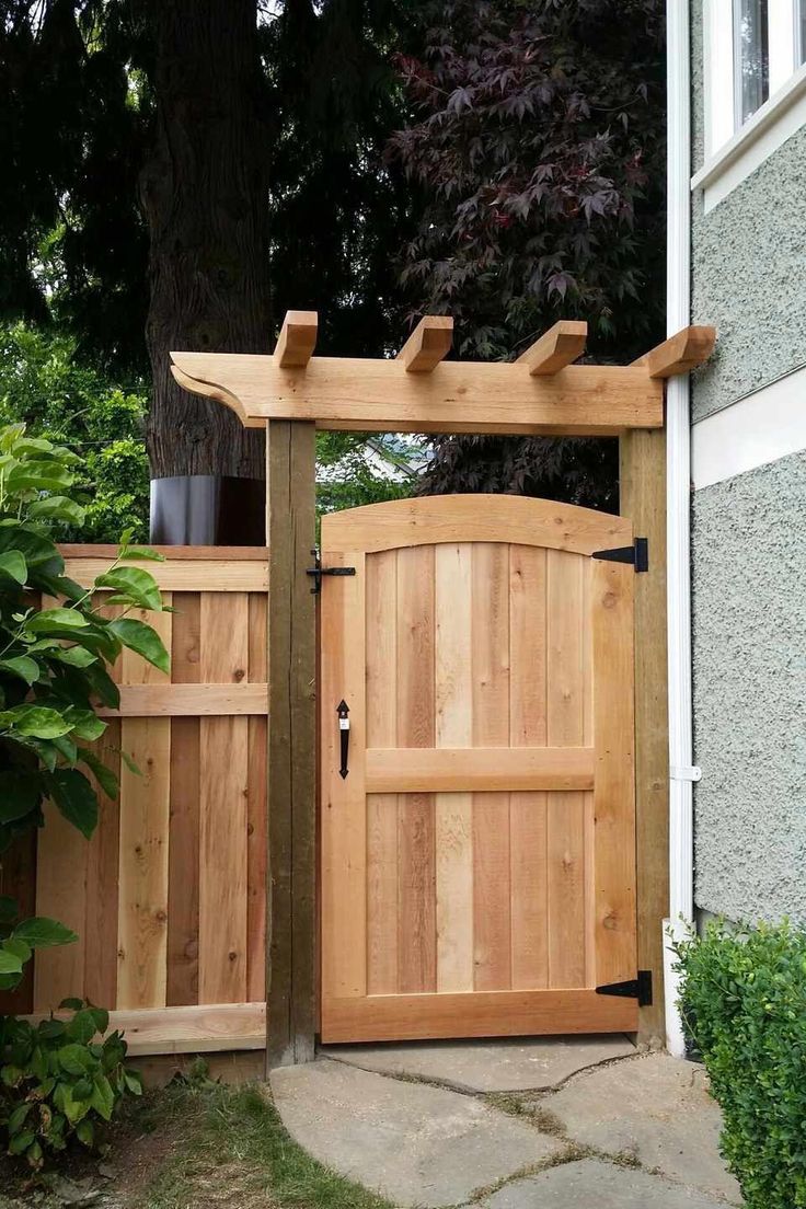 a wooden gate is open on the side of a house