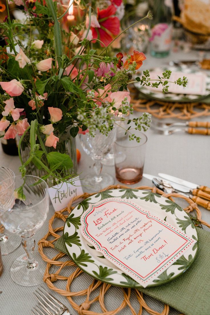 a table set with place settings and flowers