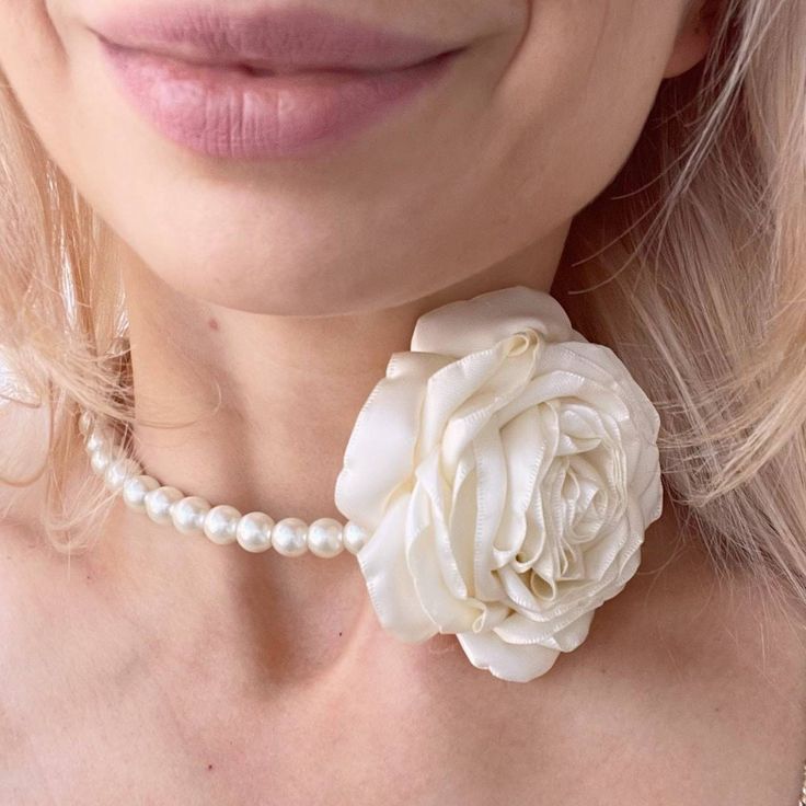 Introducing our stunning flower choker necklace that combines elegance and charm. This Pearl bridal necklace is the perfect accessory for a wedding or formal event. It's elegant design and faux pearls make it a classic and sophisticated piece that will add a touch of glamour to any bridal look. The delicate flower adds a feminine and romantic touch that will complement any wedding dress. Moreover, the choker's adjustable ribbons make it a versatile piece that can fit any neck size and can be tie Flower-shaped Necklace With Flower Decoration For Wedding, Flower Shaped Necklace With Flower Decoration For Wedding, Floral Necklace For Wedding, White Flower Bridal Necklace For Wedding, White Floral Bridal Necklace For Wedding, Adjustable Flower Necklace For Wedding, Elegant Flower Decorated Choker Jewelry, Elegant Flower Decoration Choker Jewelry, Elegant Flower Decoration Choker Necklace