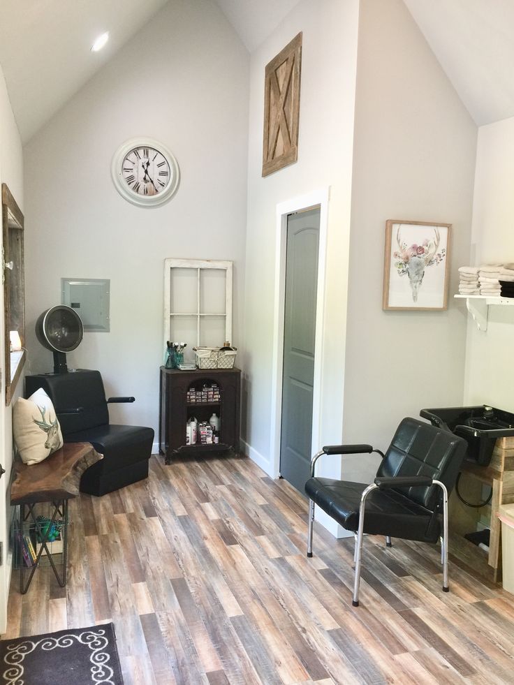 a living room filled with furniture and a clock on the wall above it's doorway