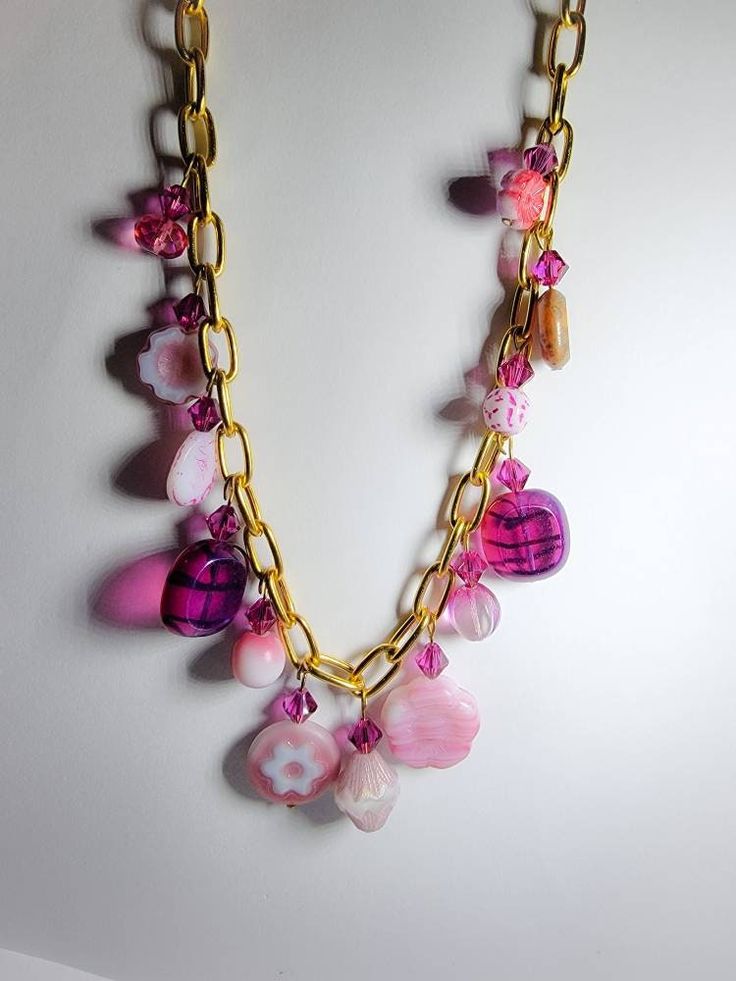 Designer Czech glass charms and fuschia Swarovski bicones dangle from a 10k gold plated 16in chain necklace. Multiple hues of pink. Luxury Czech Glass Necklaces, Pink Beaded Chain Jewelry For Gift, Pink Glass Beaded Chain Jewelry, Pink Glass Jewelry With Beaded Chain, Pink Dangle Charm Necklace With Adjustable Chain, Handmade Pink Glass Jewelry, Handmade Pink Czech Glass Jewelry, Handmade Pink Chain Necklace As Gift, Pink Chain Necklace For Jewelry Making