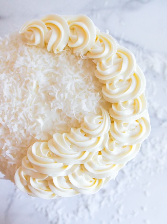 a close up view of some white frosting on top of the cake with coconut sprinkles