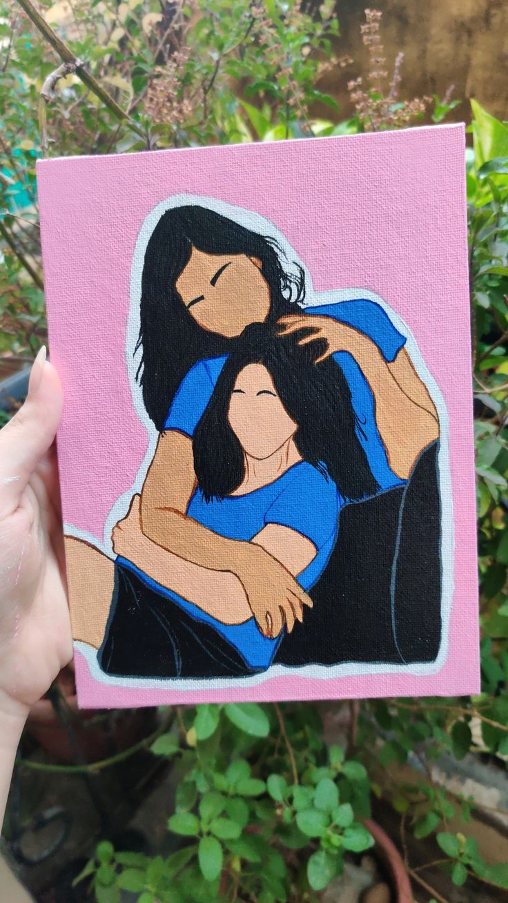 a hand holding up a painting of two people hugging each other in front of some plants