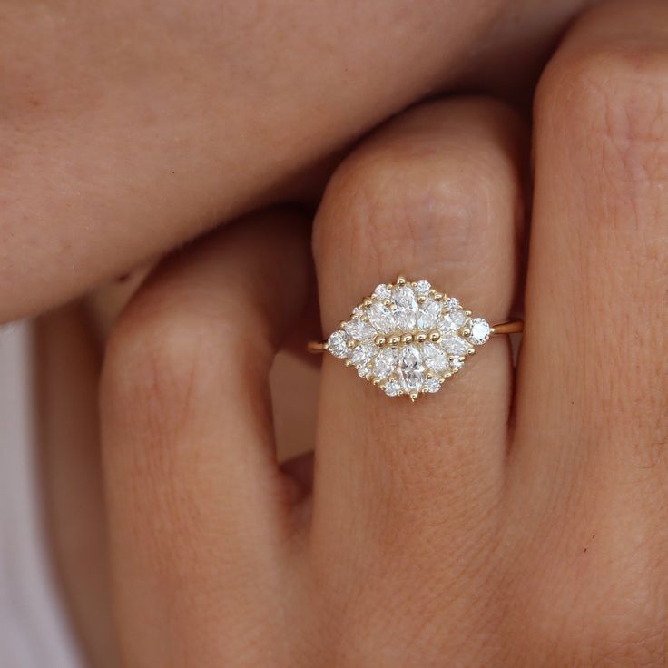 a woman's hand with a diamond ring on her finger, showing the center stone