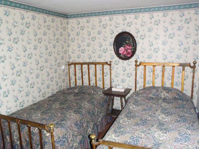 two twin beds in a room with floral wallpaper