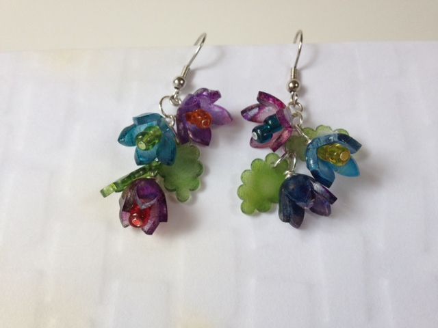 two pairs of earrings with colorful flowers hanging from them