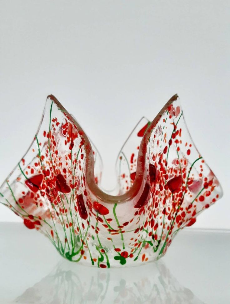 a glass bowl with red and green designs on it