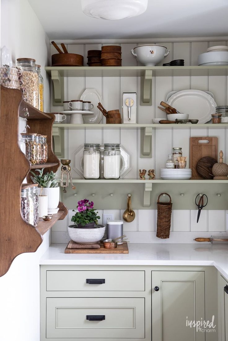 a kitchen filled with lots of dishes and utensils on top of wooden shelves