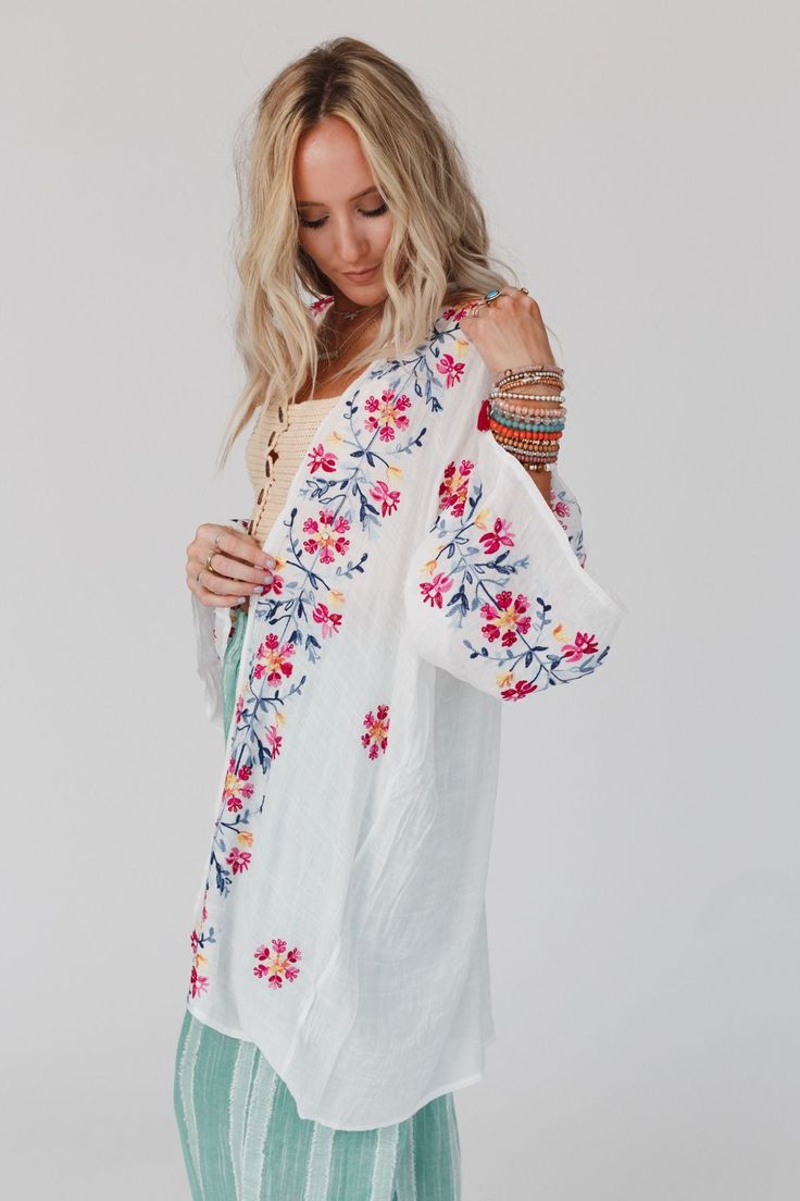 Elevate all of your favorite boho outfits with the Waikiki Beach Embroidered Kimono! This kimono is a true show - stopper, sure to get compliments when worn because it features Lightweight and flowy woven fabric with a relaxed and loose kimono silhouette Classic open front closure allows you to show off your favorite outfits underneath Long and loose kimono sleeves Stunning embroidered floral details throughout Classic boho outfit pair with: High Neck Racerack Brami, Billy Corduroy Pants, Over T Traditional Kimono For Spring Beach Cover-up, Embroidered Kimono For Spring Festival, Long Floral Embroidered Kimono For Festival, Long Floral Embroidery Kimono For Festivals, Spring Folk Kimono With Floral Embroidery, Spring Folk Style Embroidered Kimono, Summer Folk Style Embroidered Kimono, Bohemian Long Sleeve Kimono For Spring, Summer Embroidered Folk Kimono