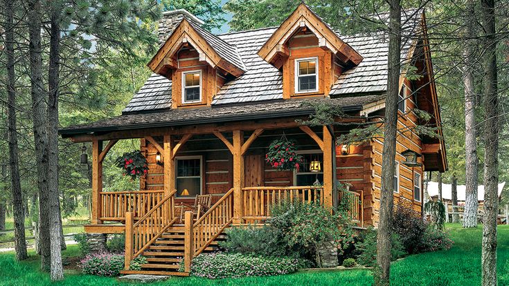 a log cabin with porch and stairs in the woods