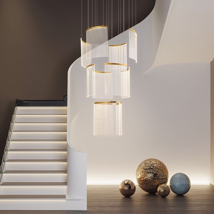 an elegant staircase with modern chandeliers and marble balls on the floor in front of it