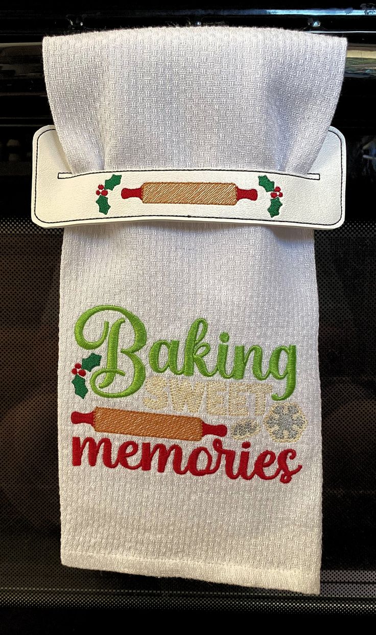 an oven mitt with the words baking memories on it and a rolling pin attached to it