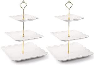 three tiered serving trays with gold handles on each side and one holding a single flower