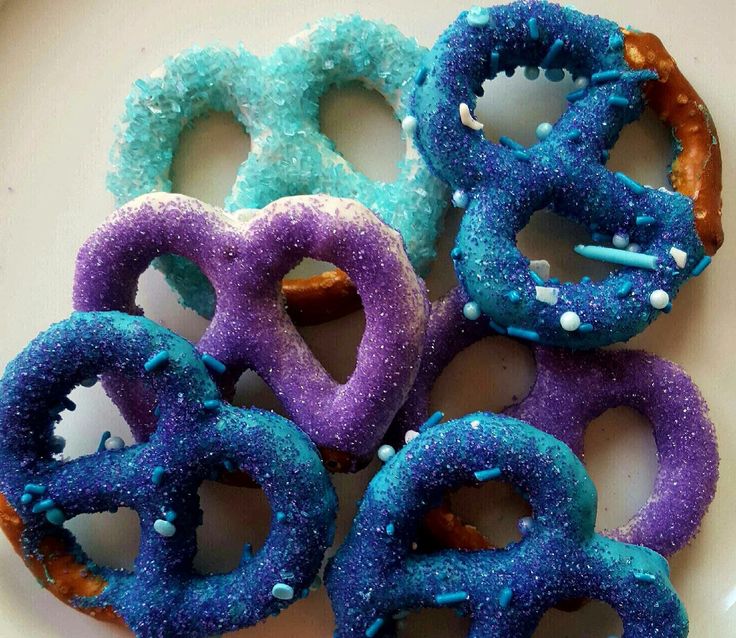 there are six donuts with blue and purple icing on the doughnuts