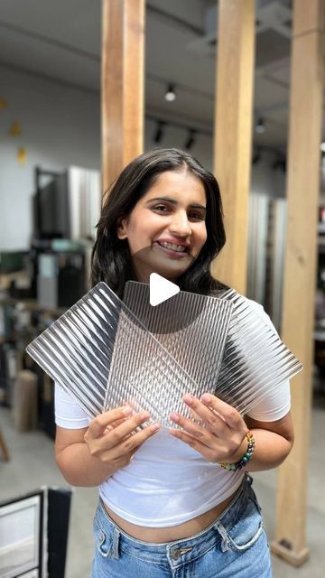 a woman standing in an office holding a piece of metal