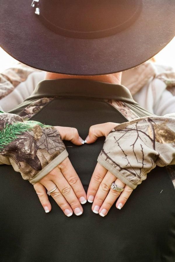 someone wearing camo gloves and a hat is holding their hands out to the camera