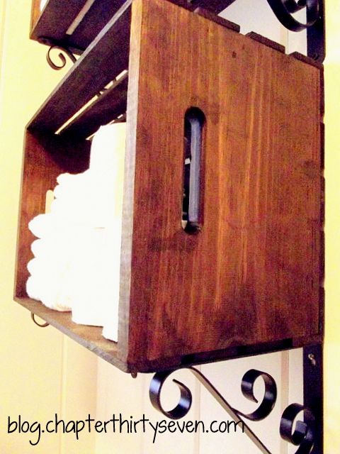 a wooden shelf with towels and napkins hanging from it's sides on a wall