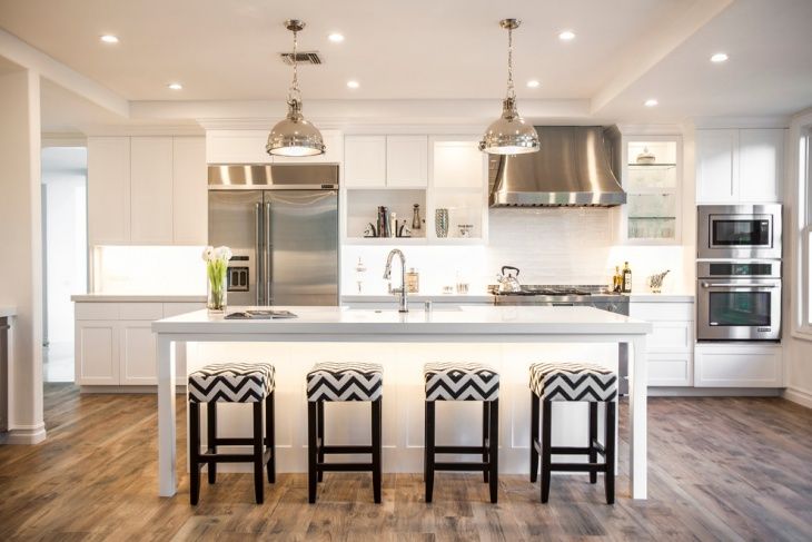 a kitchen with white cabinets and black and white bar stools next to an island