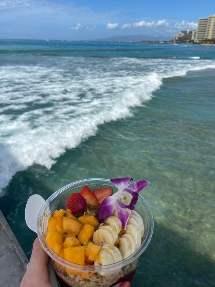 Holding an açaí bowl with mango, banana, strawberry, overlooking crashing waves Hawaii Life Aesthetic Food, Hawaii Poke Bowl Aesthetic, Acai Bowl Aesthetic Beach, Honolulu Hawaii Aesthetic, Hawaii Breakfast, Acai Bowl Aesthetic, Uh Manoa, Food Hawaii, Honeymoon Vibes