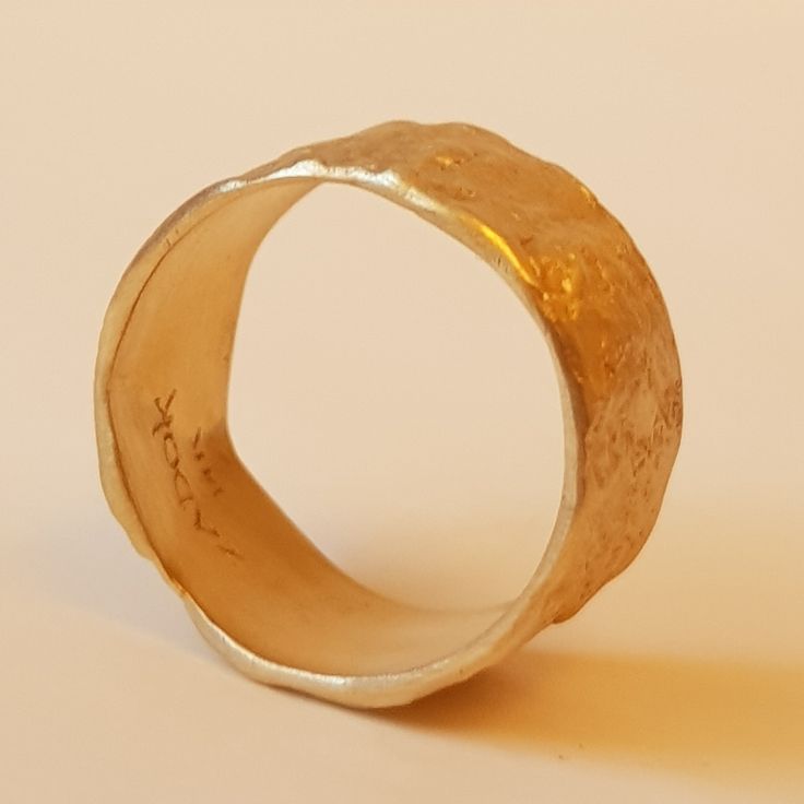 Organic form meets expert craftsmanship with this stunning solid 18K gold women's wedding band. A subtle yet sensational statement, this piece has an apparent weight and impressive width with naturally undulating sides and a rough-textured surface. Each ring is handcrafted and one of kind just like the singular union they represent. ◈ DETAILS Weight: 6g Width: 12-13mm / 0.47''- 0.51'' Thickness: 1.1-1.5mm / 0.39''- 0.06'' ◈ MATERIAL 18K Solid Gold ◈ ALSO AVAILABLE IN 14K Yellow, Rose, or White G Gold Hammered Promise Ring, Gold Hammered Round Band For Wedding, Hammered Yellow Gold Promise Jewelry, Hammered 14k Gold Engraved Ring, Promise Jewelry In Hammered Yellow Gold, Heirloom Yellow Gold Hammered Engraved Ring, Heirloom Engraved Yellow Gold Ring With Hammered Detail, Heirloom Engraved Hammered Yellow Gold Ring, Gold Hammered Thick Band Ring