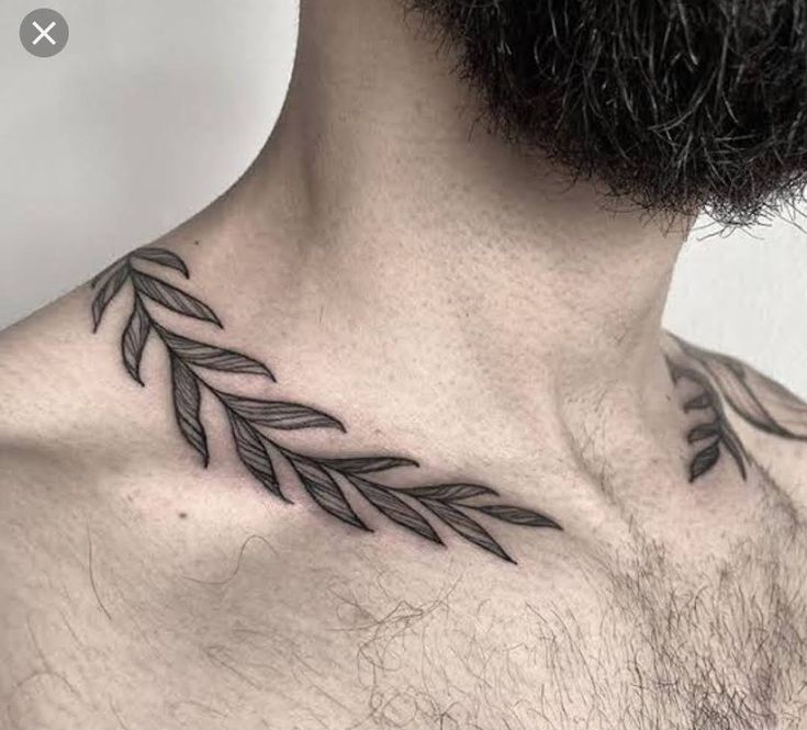 a man's chest with an arrow tattoo on his chest and the back of his neck