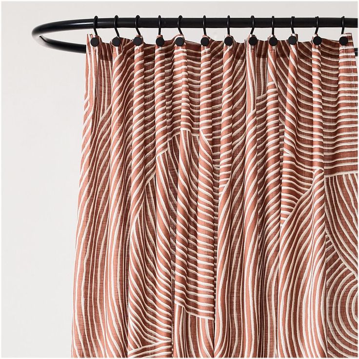 an orange and white curtain hanging from a metal rod