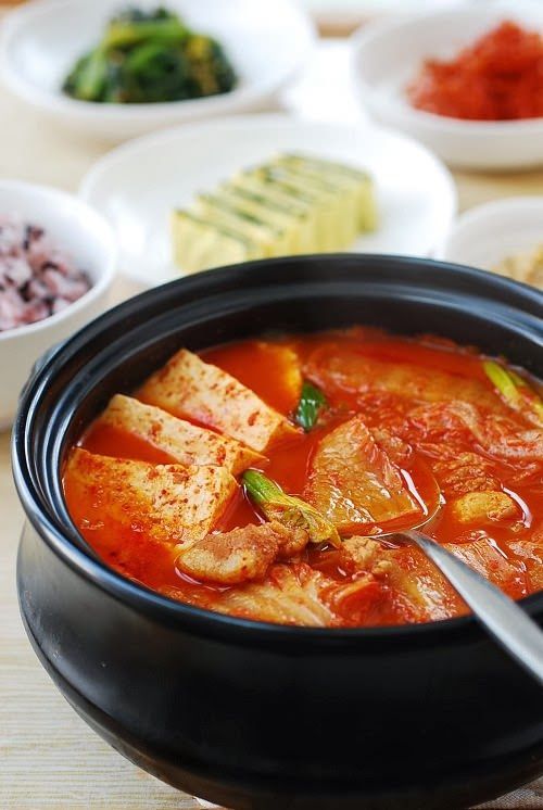 there are many different bowls of food on the table, including rice and tofu