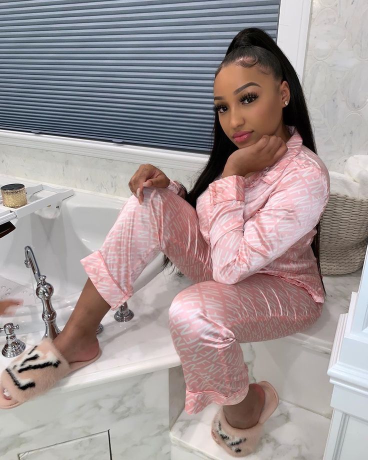 a woman sitting on top of a bath tub next to a sink