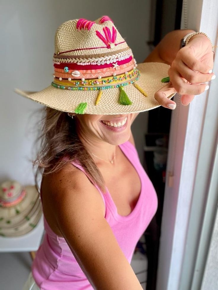 Looking for a unique and stylish sun hat to take on your next vacation? Look no further than our Colombian Hat! Handcrafted by Colombian artisans, this natural straw hat is accented with assorted adornments, making it the perfect wearable art accessory. Whether you're hitting the trails or the beach, be sure to grab a Colombian Hat!  Each hat is unique some of the charms or fringes may vary slightly from the picture. Colombian Hat Details: 100% Straw. Small: 21 inches (54-55 cm) Medium: 22 inche Artisan Hat For Spring Vacation, Artisan Spring Vacation Hat, Adjustable Tropical Fedora Straw Hat, Artisan Wide Brim Panama Hat For Beach, Artisan Wide Brim Panama Hat For Vacation, Artisan Natural Hat Band For Beach, Artisan Panama Hat With Curved Brim For Beach, Multicolor Summer Fedora For Vacation, Artisan Natural Panama Hat For Vacation