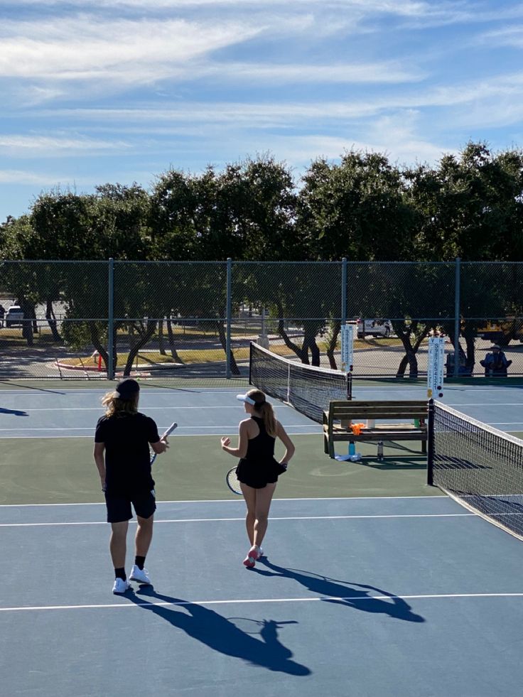 two tennis players are walking on the court