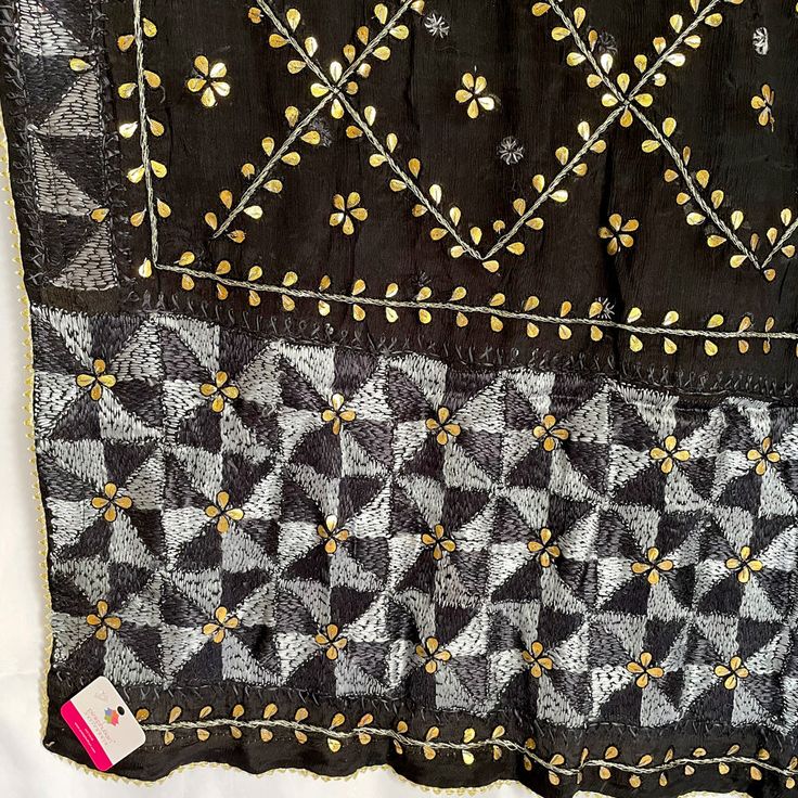 This traditional black silk phulkari gotta patti work dupatta is meticulously crafted with luxurious pure Chinon silk, featuring all over Gotta Patti hand embroidery and boasts a striking metallic gold trim along the border. This classic piece is perfect for celebrations such as weddings, sangeet, jaago, and chunni ceremonies. Effortlessly pair this dupatta with any color for an elegant contrast and make it an admirable present for birthdays or anniversaries. Material: Pure silk chinonWork: Silk Black Kurta With Cutdana Traditional Drape, Black Embroidered Fabric For Designer Wear During Eid, Elegant Black Salwar Kameez With Cutdana, Designer Black Tussar Silk Saree, Black Chanderi Traditional Wear, Black Tussar Silk Traditional Wear With Zari Work, Black Tussar Silk Dupatta With Traditional Drape, Black Tussar Silk Traditional Wear With Traditional Drape, Black Zari Work Saree For Eid