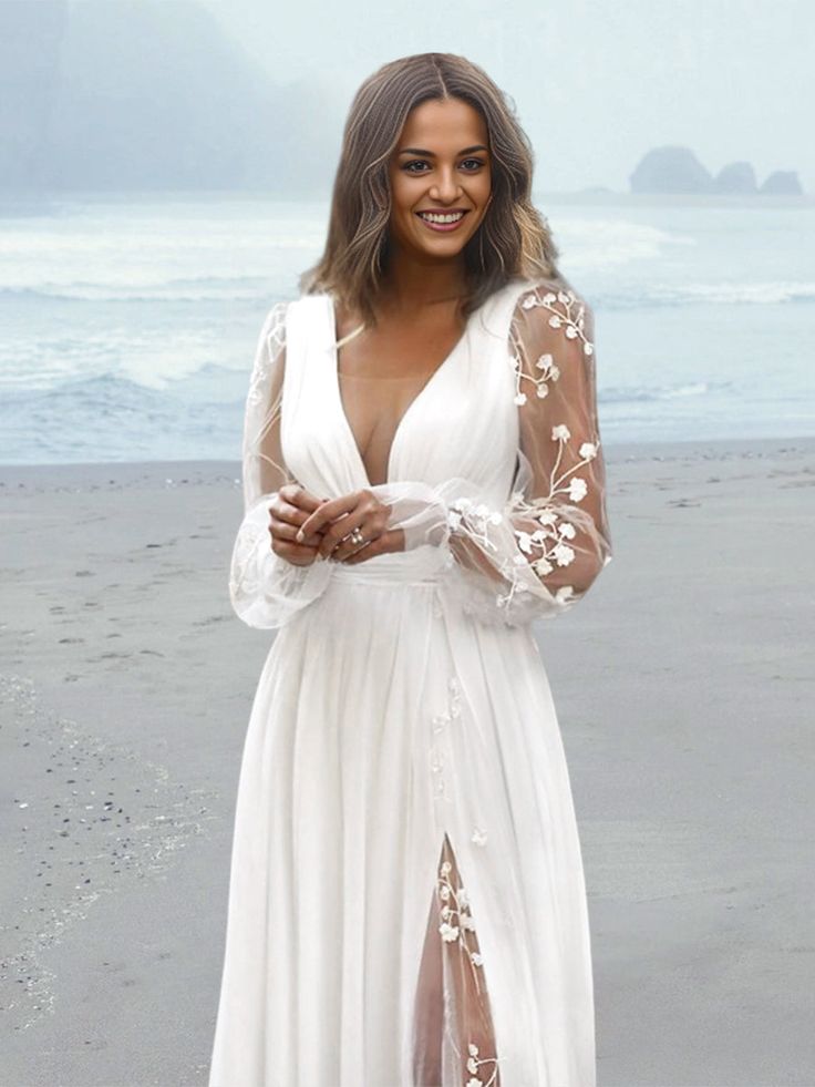 a woman standing on top of a beach next to the ocean wearing a white dress