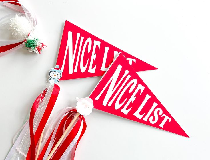 two red and white pennants with the words noelly next to them on a table