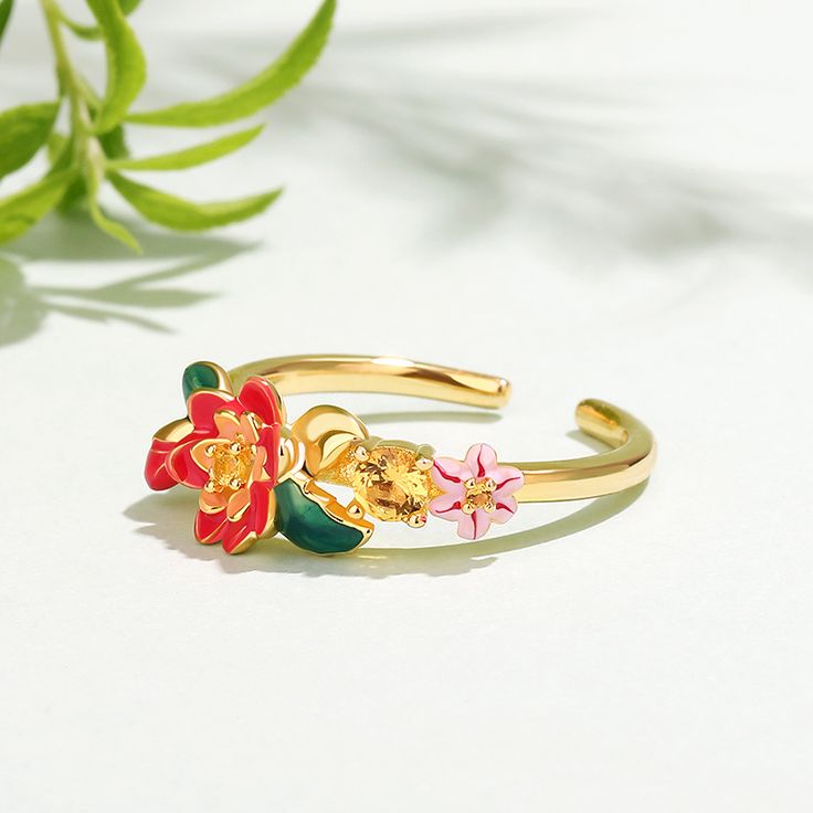 This beautifully detailed ring boasts charming flowers in bright shades of multicolored enamel. The intricate flawless enamel work coupled with sparking stones, make this an eye-catching piece.Carat Weight: 0.205 ctStone Size: 1.7,1.3,3.5 mmStone Type: Jeulia® StoneNumber of Stones: 3 Stone Shape: RoundStone Color: Citrine YellowWeight: 2.8 gWidth: 20.4 mmHeight: 5.2 mmThickness: 1 mmMaterial: 925 SilverPlating Color: Yellow Gold Gold Enamel Flower Ring For Anniversary, Floral Enamel Wedding Jewelry, Yellow Gold Enamel Flower Ring Gift, Enamel Flower-shaped Jewelry For Wedding, Flower Shaped Enamel Jewelry For Wedding, Flower-shaped Enamel Jewelry For Wedding, Flower Shaped Enamel Wedding Jewelry, Enamel Flower Shaped Wedding Jewelry, Yellow Gold Enamel Flower Jewelry