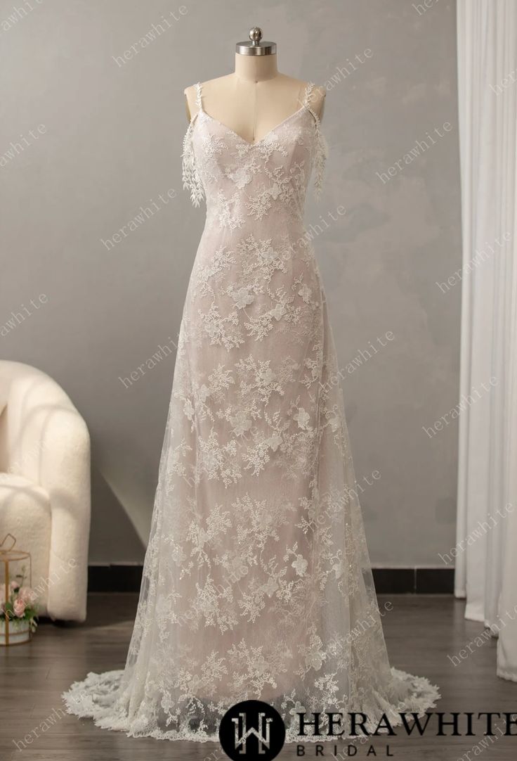 a wedding dress on display in front of a white chair with flowers and greenery