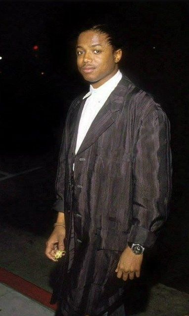 a man in a suit and tie standing on the sidewalk