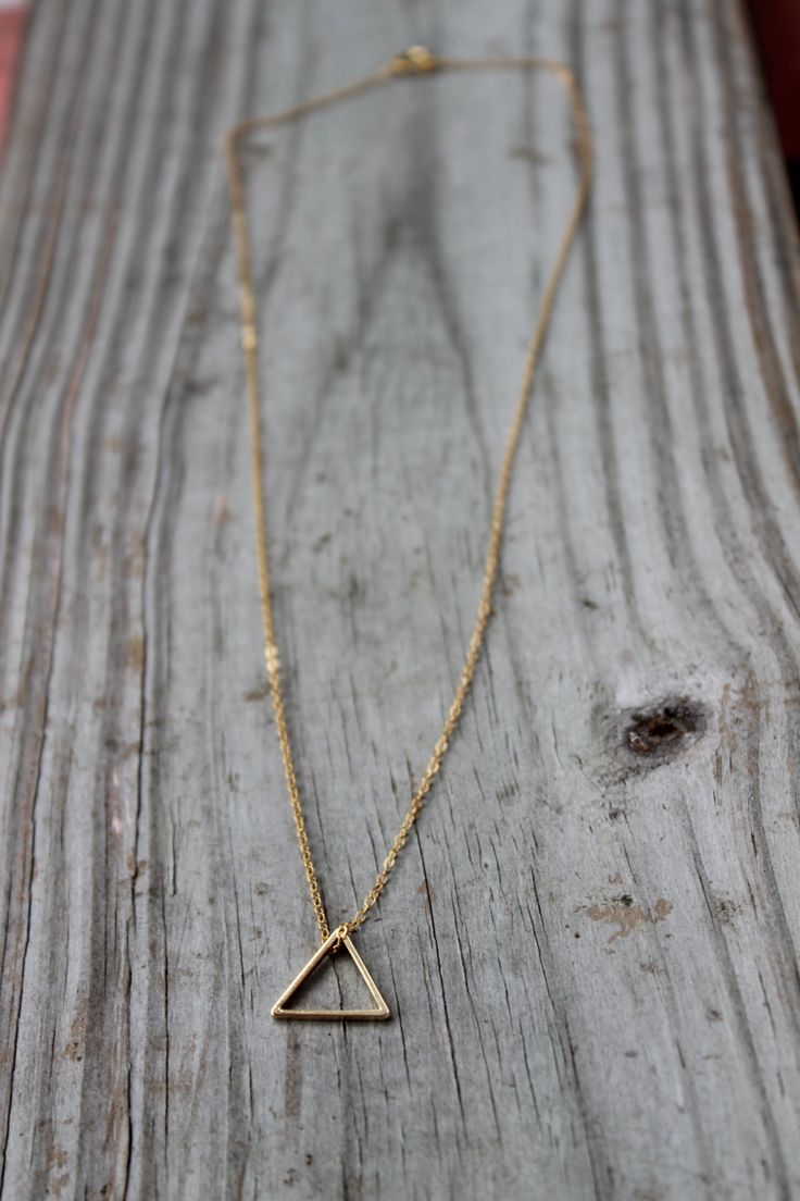 "A beautiful, shiny gold triangle strung from a gold plated or 14k gold filled chain. This simple, everyday minimalist necklace is the perfect piece to wear alone or layered with other necklaces. It makes the perfect gift for yourself or any loved one. You'll surely love the dainty design of the simple triangle necklace. D E T A I L S: Triangle - Gold Plated Brass - Approximately 1/2\" wide - Beautiful & shiny Chain - Gold plated brass or 14k gold filled - Any length up to 18\" - Delicate, b Minimalist Geometric 14k Gold Jewelry, Minimalist 14k Gold Geometric Jewelry, Minimalist Geometric Jewelry In 14k Gold, Gold Geometric Minimalist Necklace, Minimalist Geometric Gold Jewelry, Minimalist Gold Geometric Necklace, 14k Gold Triangle Jewelry, 14k Gold Triangle Shaped Jewelry, 14k Gold Triangle Jewelry In Gold Color