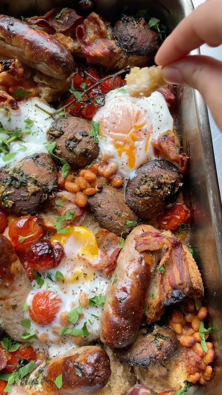 a person is taking an egg and sausage breakfast from a roasting pan on the stove