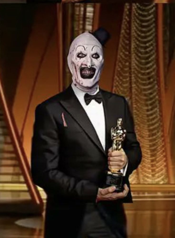 a man in a tuxedo holding an award