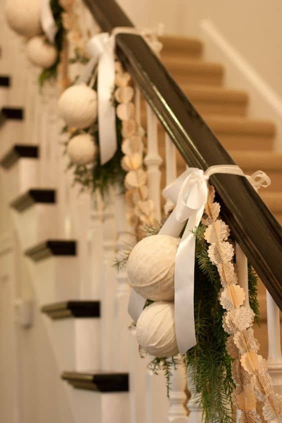 some balls and greenery are hanging on the banister