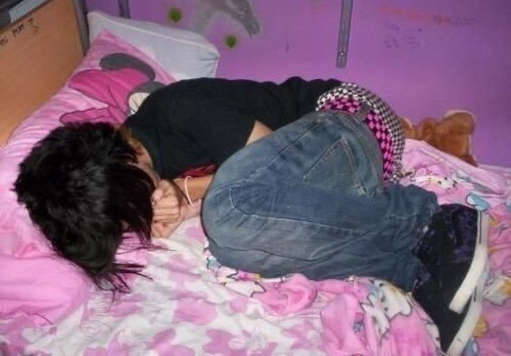 a woman laying on top of a bed next to a teddy bear