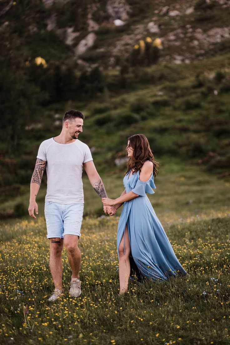 a man and woman holding hands in a field