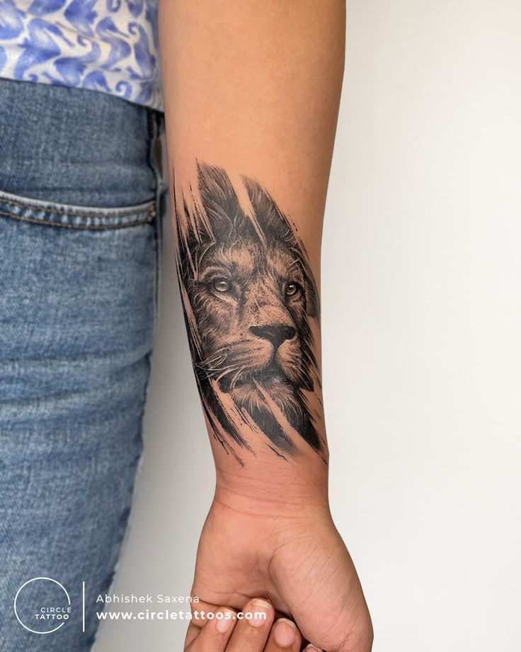 a woman's arm with a lion tattoo on it