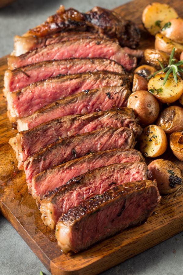 steak and potatoes on a wooden cutting board