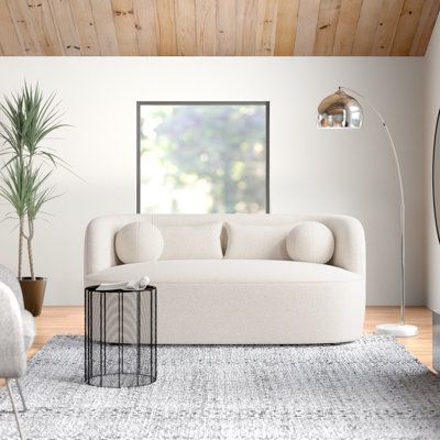 a living room with white furniture and wood ceiling