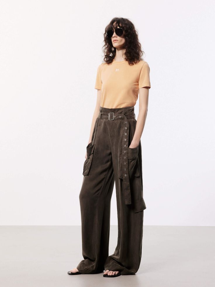 MO&Co. Women's Wide Leg Cargo Pants These pants are made from sustainable and eco-friendly materials, featuring a wide-leg and cargo style making them a fashionable and practical choice for a casual or streetwear look. The wide pocket design adds functionality and versatility, perfect for carrying essentials while on the go, and the belt ensures a secure fit and adds an extra touch of style. The brown pants may appear olive or khaki under different lighting. Features : - Wide leg in cargo style, Wide Leg Trousers With Multiple Pockets For Fall, Fall Wide Leg Trousers With Multiple Pockets, Fall Wide Leg Pants With Cargo Pockets, Utility Wide Leg Pants With Cargo Pockets For Workwear, Summer Utility Pants With Belt Loops, Versatile Relaxed Fit Wide Leg Pants With Belt Loops, Versatile Wide Leg Cargo Jeans With Side Pockets, Elevated Casual Wide Leg Pants With Side Pockets, Elevated Casual Wide-leg Bottoms With Side Pockets