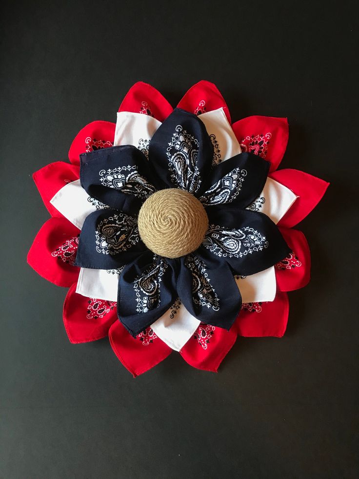 a red, white and blue flower with a straw in the center on a black surface