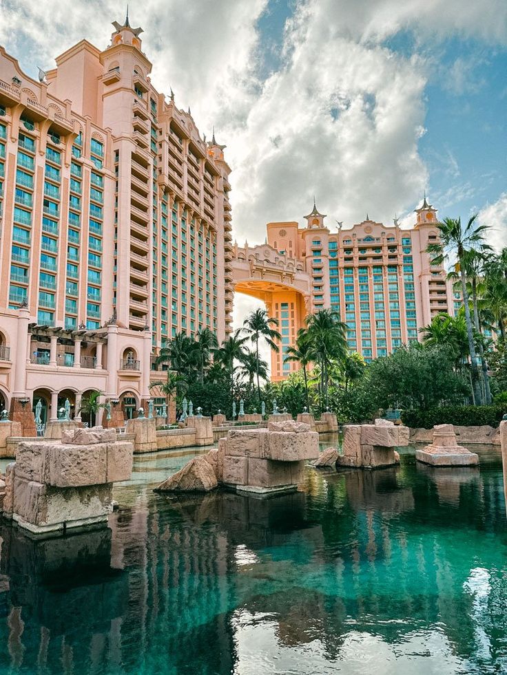 the hotel and casino are next to each other in front of blue water with palm trees on either side